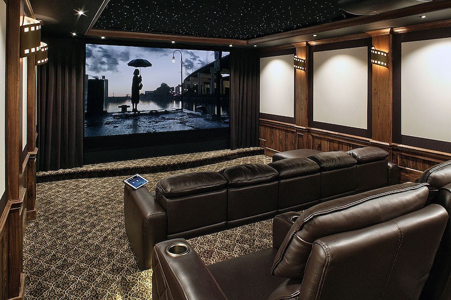 A cozy home theater with leather chairs, large screen, and a StarField ceiling