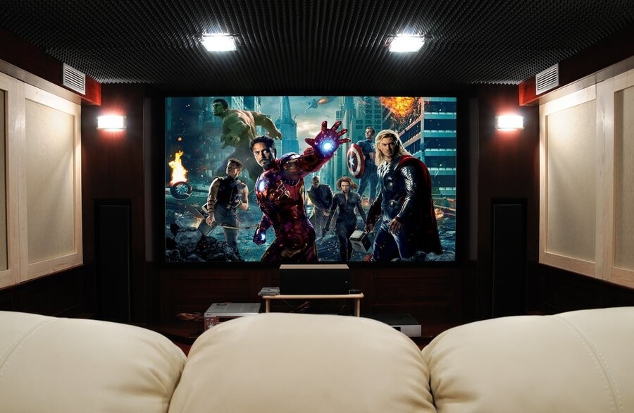 A home theater design and setup featuring theater seating, acoustic treatments, and a large screen showing The Avengers (2012).