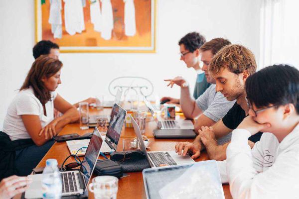 employees and friends working on laptops in room